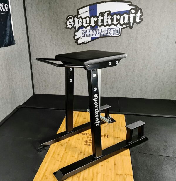 Urheilija tekee alaselkätreeniä SportKraft Reverse Hyper -laitteella kuntosalilla.